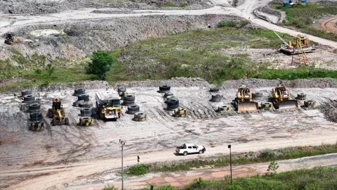 An aerial view of rigid dump trucks and excavators parked in a row at a coa.. 動画素材 343248758