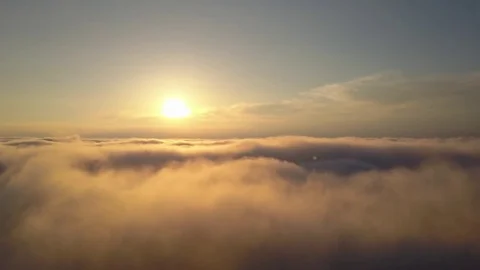 Aerial view rising above clouds and mist to see the sun Stock Footage 77062778
