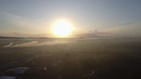 Aerial view of the rising sun behind the mountains in the town of Batulicin.. Stock Footage 246541638