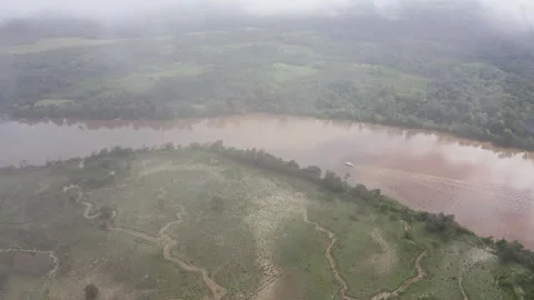 Aerial View of River in Amazon Rainforest with Low Clouds and Boat Stock Footage 311411469