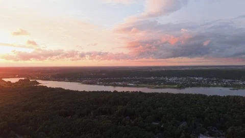 Aerial View of River and Forest at Sunset with Vibrant Clouds Stock Footage 341996676