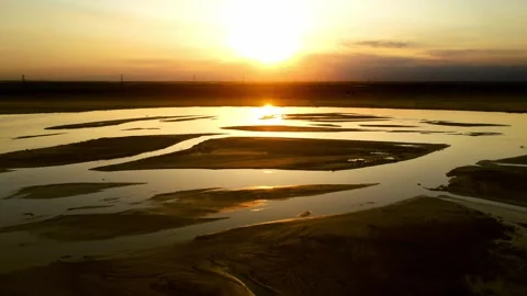 Aerial view of the river and plain under the setting sun Stock Footage 296144300