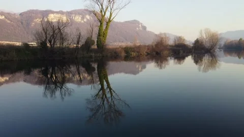 Aerial view of a river with bare trees at sunset Stock Footage 166527639