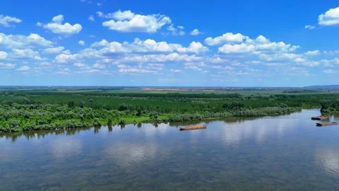 Aerial view of river barge passing by forest and farmland 動画素材 308376187