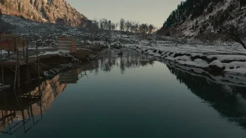 Aerial view of a river in between the mountains covered with snow Stock Footage 172473480