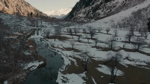 Aerial view of a river in between the mountains covered with snow Stock Footage 172521673
