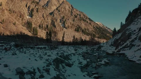 Aerial view of a river in between the mountains covered with snow Stock Footage 172522429