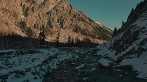 Aerial view of a river in between the mountains covered with snow Stock Footage 172523161