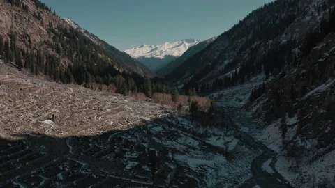 Aerial view of a river in between the mountains covered with snow Stock Footage 172523558