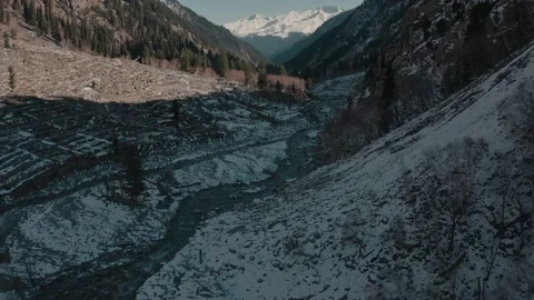 Aerial view of a river in between the mountains covered with snow Stock Footage 172537353