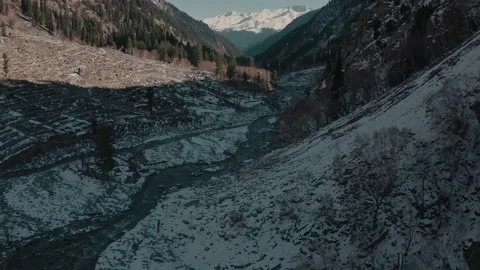 Aerial view of a river in between the mountains covered with snow Stock Footage 172537454