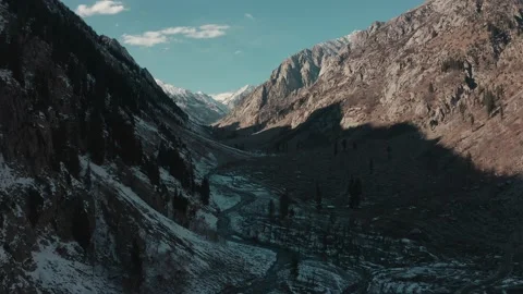 Aerial view of a river in between the mountains covered with snow Stock Footage 172537774