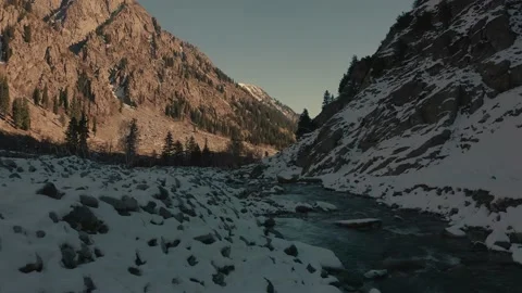 Aerial view of a river in between the mountains covered with snow Stock Footage 172538418