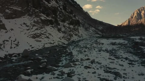 Aerial view of a river in between the mountains covered with snow Stock Footage 172538735