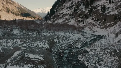 Aerial view of a river in between the mountains covered with snow Stock Footage 172538868