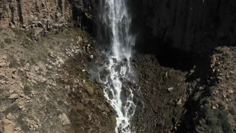 Aerial view of a river between rocks on a wet dirt road, the water flows Stock Footage 171597789