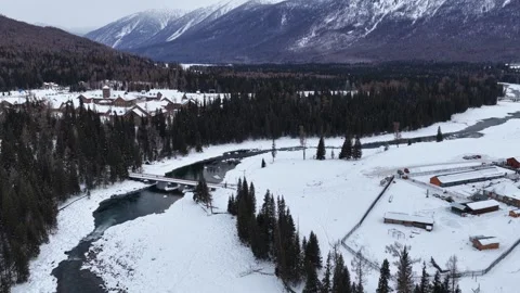 Aerial view of river bridge and snowy mountains in Xinjiang Stock Footage 336598095
