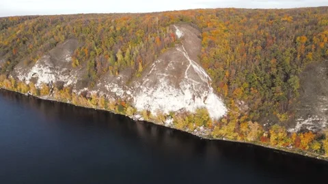 Aerial view of river coastline with limestone cliffs covered with autumn trees. Stock Footage 219222860