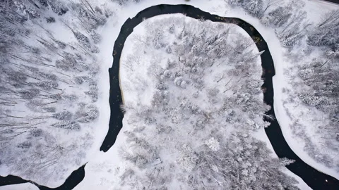 Aerial view of a river cutting through a peaceful winter landscape in Northern Vidéo 340869505
