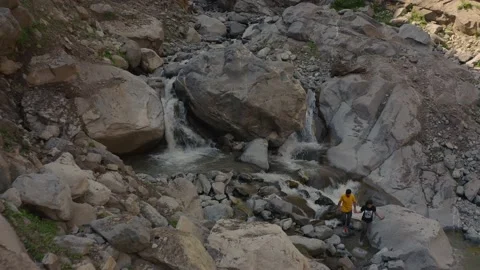 Aerial view of  a river flowing from large rocks in the mountains Stock Footage 171826281