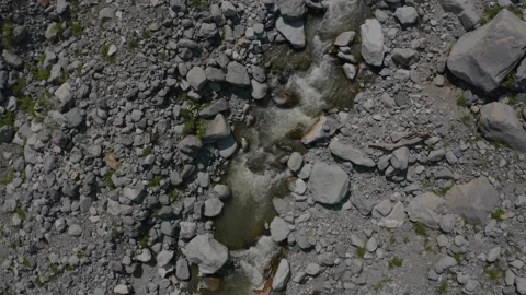 Aerial view of  a river flowing from rocks in the mountains Stock Footage 171908153