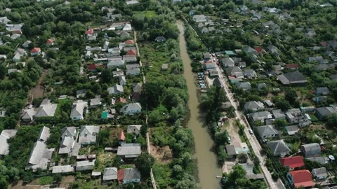 Aerial view of the river flowing through the village on a summer day. Video stock 158694497