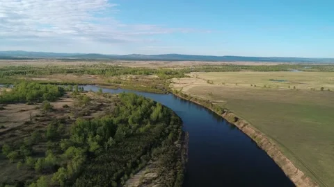Aerial view of a river flowing through rural area with meadows, rare trees Stock Footage 185269728