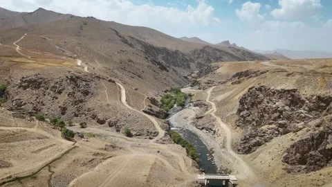 Aerial View of River Flowing Through Rocky Mountain Valley in Afghanistan Stock Footage 317940288