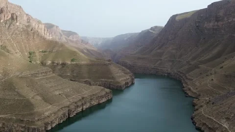 Aerial View of a River Flowing Through Dramatic Mountain Canyon Stock Footage 345634008