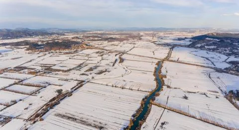 Aerial view of a river flowing through winter countryside. Stock Photos