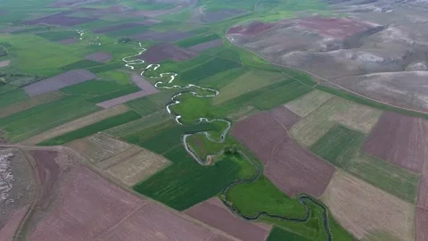 Aerial view of river meander flowing through agricultural fields on a flat Stock Footage 333717897