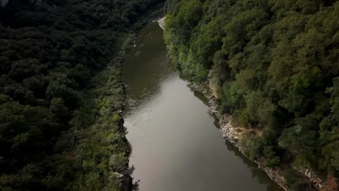 Aerial View of River Meandering Through Forested Valley in Vidéo 336610530