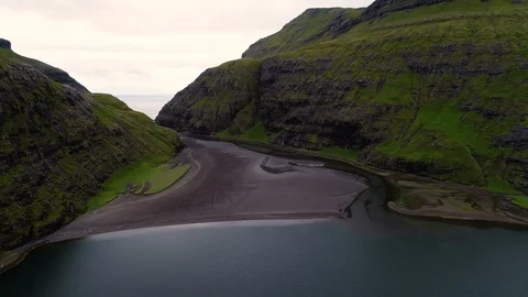 Aerial view of river passing between rock formation cliff, Faroe island. Stock Footage 102137626