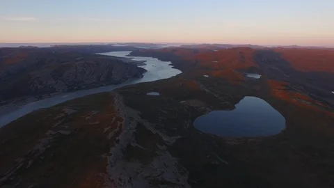 Aerial view of river passing through Northeastern Greenland landscape at sunset Video stock 104224080
