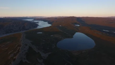 Aerial view of river passing through northeastern Greenland landscape at sunset Stock Footage 104224144