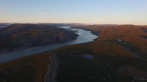 Aerial view of river passing through northeastern Greenland landscape at sunset Stock Footage 104224178