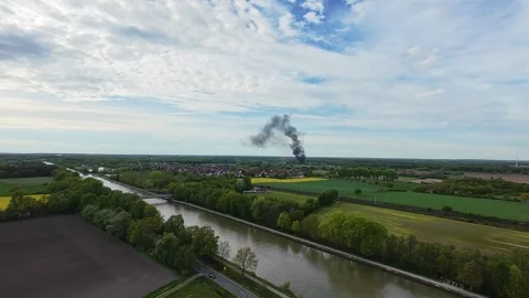 Aerial view of river, smoke stack, bridge, trees, fields, industrial contrast 4K Stock Footage 277590843