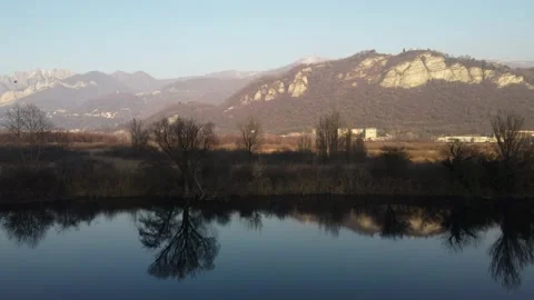 Aerial view of a river at sunset with a flying duck and mountains Stock Footage 166527604