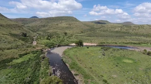 Aerial view of a river surrounded by beautiful mountains. Stock Footage 214356925