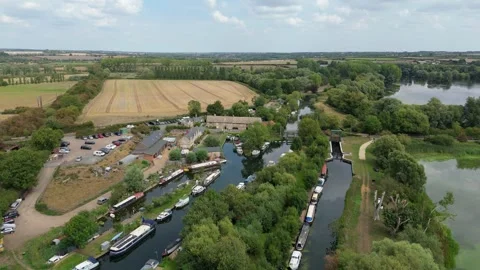 Aerial view of river system, small village and rural landscape in summer UK Video stock 322913470