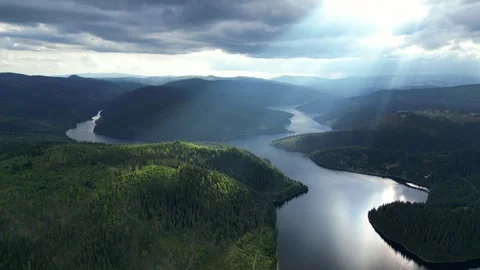 Aerial View of River Through Forest with Sun Rays Breaking Through Cloud Stock Footage 301100655