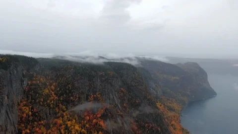 Aerial view of the river under a cliff of a mountain with a forest at the top Video stock 120653880