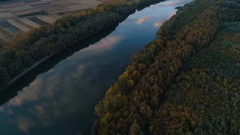 A aerial view of a river which is reflecting the sky the forest located on on Stock Footage 113427441