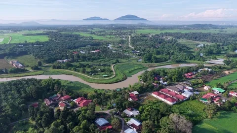 Aerial view of a river winding through a lush village Видео 344813469