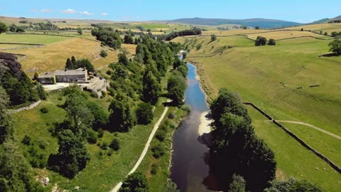 Aerial view of river winding through lush green fields. Yorkshire Dales,  R.. Stock Footage 346285588