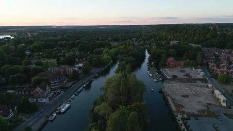 Aerial view of a riverbend lined with trees and buildings at dusk. Stock Footage 340522368