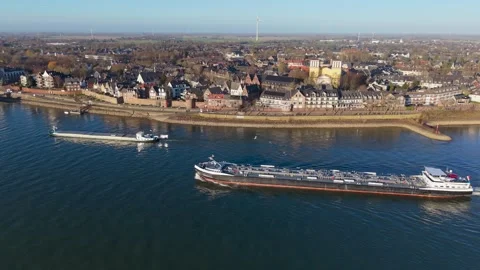 Aerial view of a riverside town featuring two cargo ships a stone embankment Stock Footage 329076412