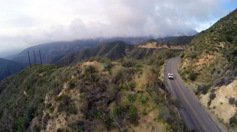 Aerial View of road and cloudy desert mountain range Stock Footage 56447757