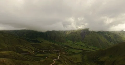 Aerial view of the road and mountains under a cloudy sky Stock Footage