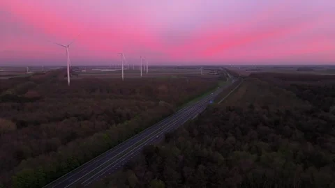 Aerial view of road and wind generators silhouetted by setting sun Stock Footage 313153161